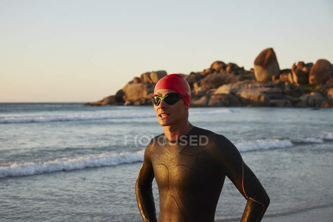 Пловец-триатлонист в гидрокостюме на берегу океана — стоковое фото