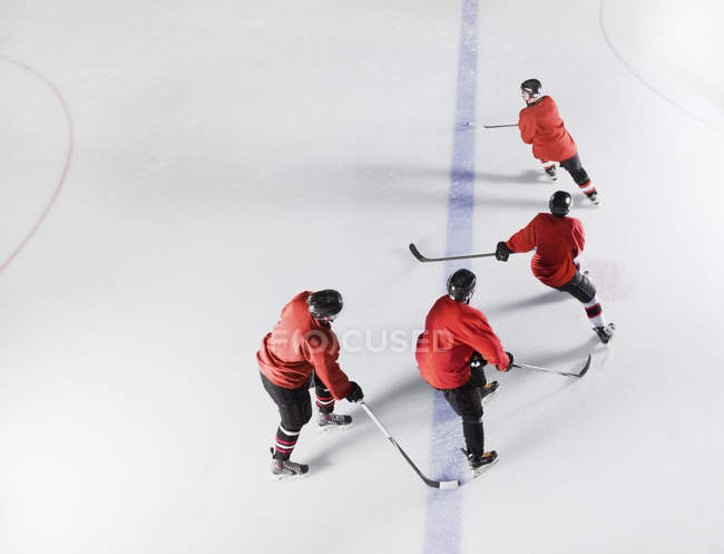 Команда з хокею в червоних лівреях катання на льоду — стокове фото