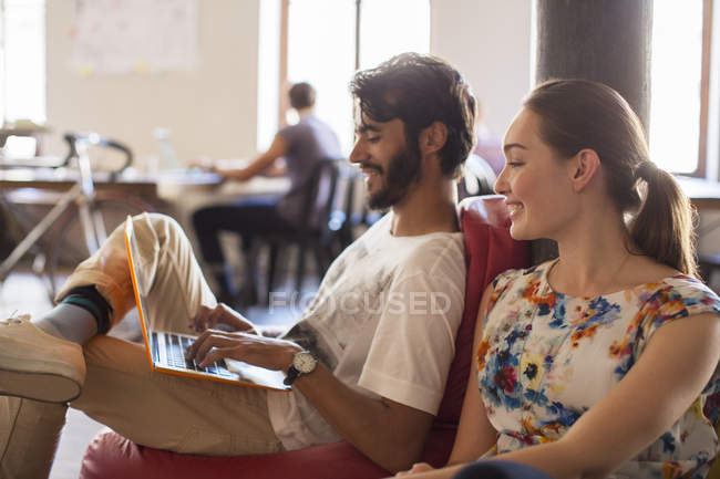 Casual business people using laptop in office — Stock Photo