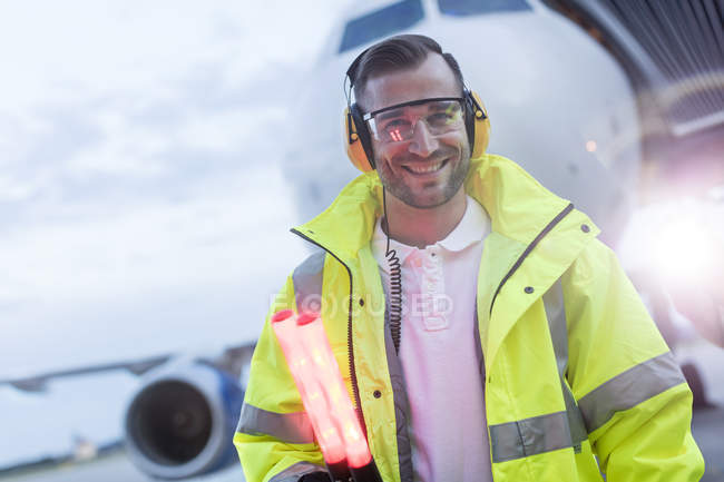 Retrato sorrindo controlador de tráfego aéreo na frente do avião no asfalto — Fotografia de Stock