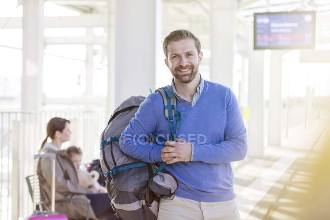 Retrato sorridente homem com mochila no aeroporto — Fotografia de Stock