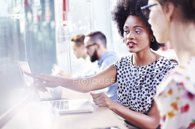 Businesswomen using laptop in modern cafe — Stock Photo
