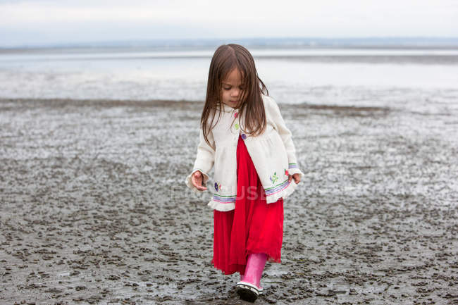 Chica en vestido caminando en la playa - foto de stock