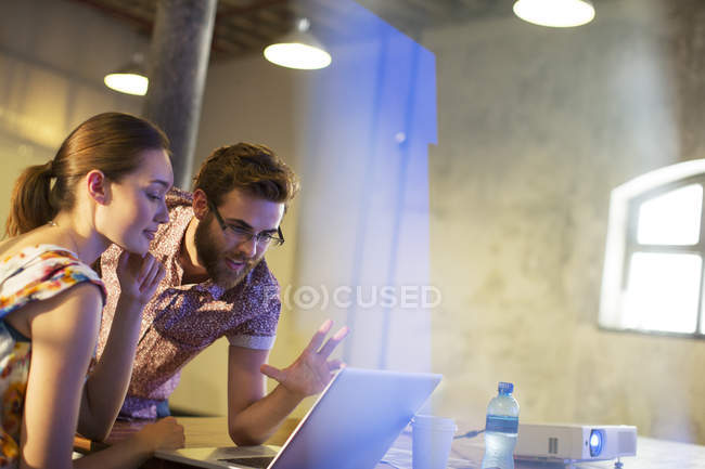 Businessman explaining female colleague something on the laptop — Stock Photo