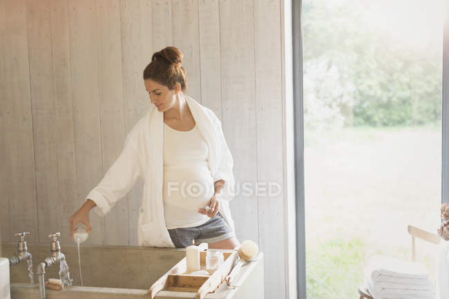 Pregnant woman preparing bubble bath — Stock Photo