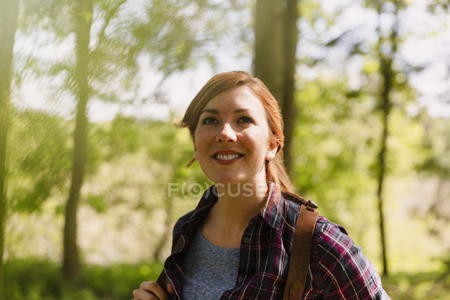 Portrait smiling woman with red hair hiking in woods — Stock Photo