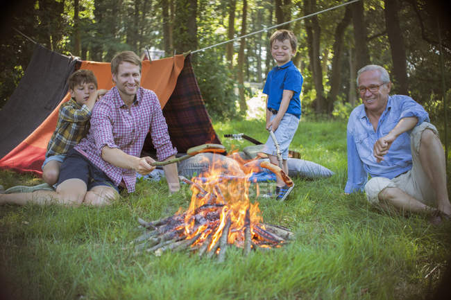 Ragazzo, padre e nonno si rilassano vicino al falò — Foto stock