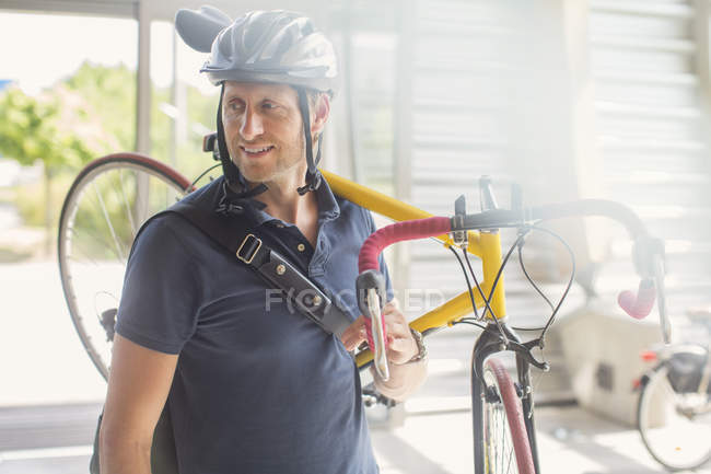 Homem carregando bicicleta no ombro — Fotografia de Stock