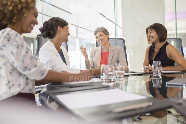 Деловые женщины сидят за столом переговоров и говорят: — стоковое фото