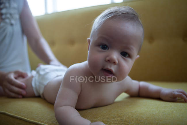 Портрет маленької дитини, що лежить спереду на жовтому дивані — стокове фото