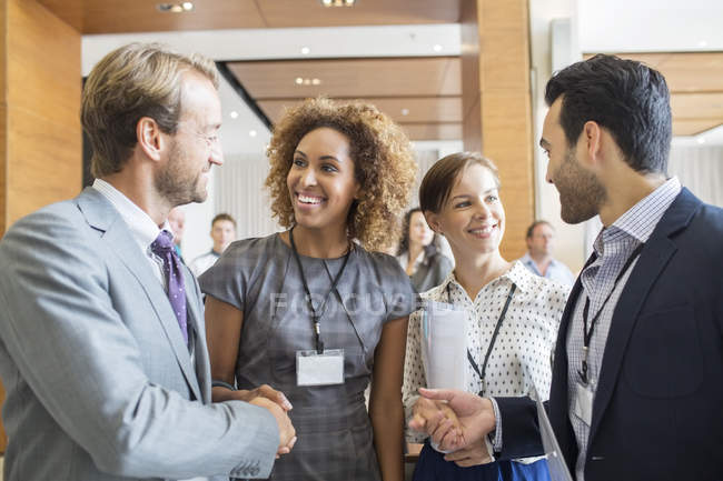 Four business people shaking hands at beginning of meeting — Stock Photo