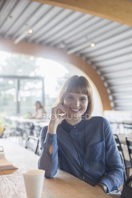 Businesswoman sitting at table in cafeteria — Stock Photo