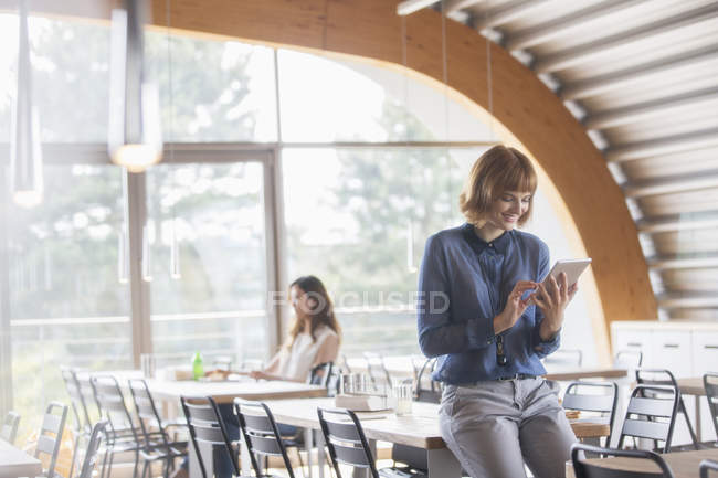 Geschäftsfrau nutzt digitales Tablet in Cafeteria — Stockfoto