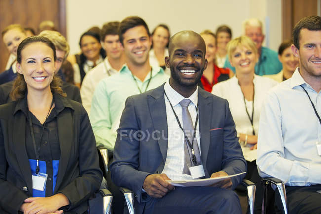 Усміхнений бізнесмен сидить у конференц-залі, дивлячись на камеру — стокове фото