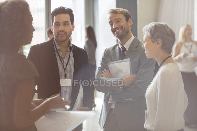 Grupo de empresarios sonriendo y discutiendo en la oficina - foto de stock