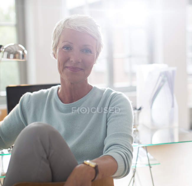 Geschäftsfrau lächelt am Schreibtisch — Stockfoto