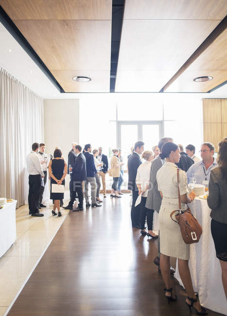 Large group of people socializing in lobby of conference center during coffee break — Stock Photo