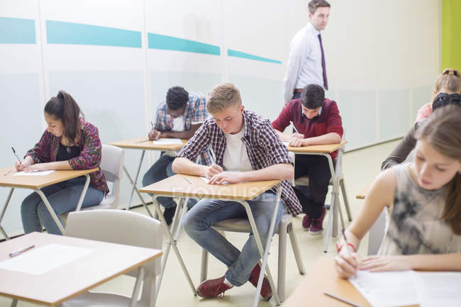 Students writing their GCSE exam in classroom — Stock Photo