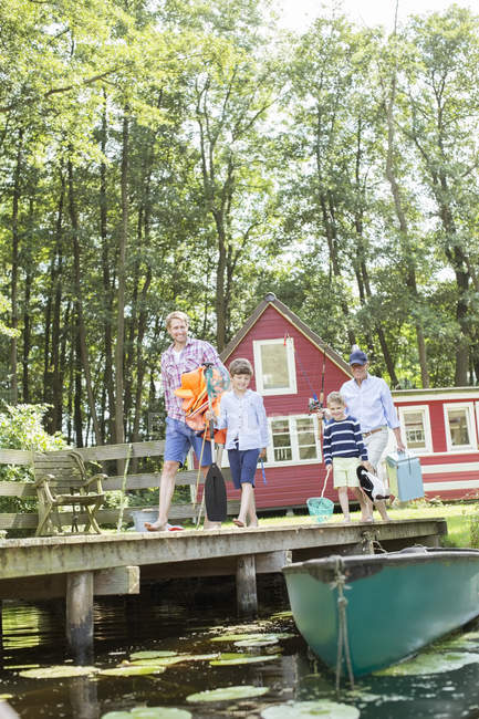 Brothers, father and grandfather walking on dock — Stock Photo