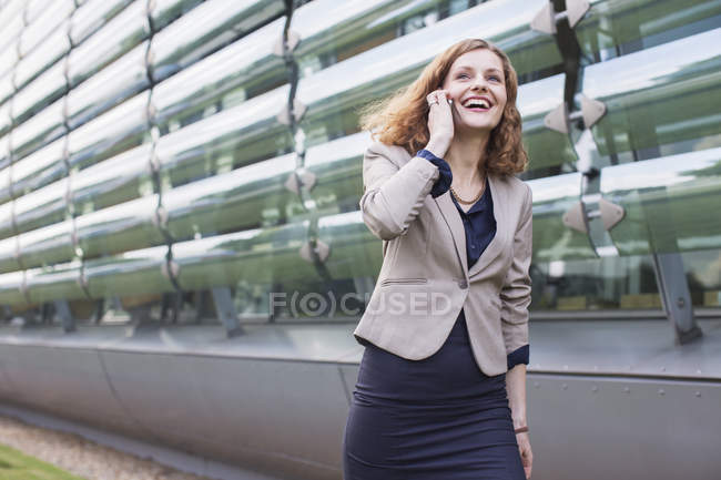 Деловая женщина разговаривает по мобильному телефону на открытом воздухе — стоковое фото