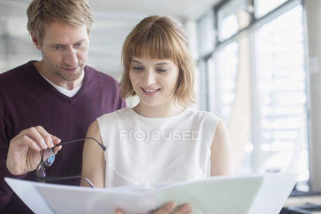 Business people reading paperwork in office — Stock Photo