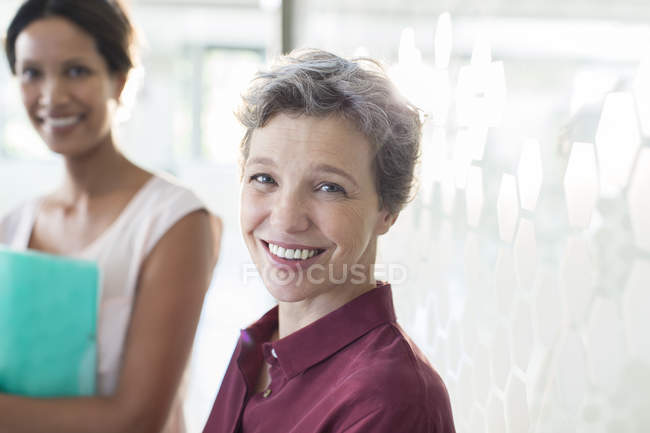 Retrato de duas empresárias sorridentes no cargo — Fotografia de Stock