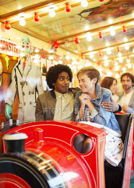 Man embracing scared girlfriend on ghost train — Stock Photo