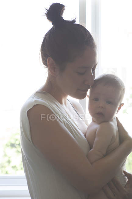 Retrato de la madre sosteniendo al bebé - foto de stock