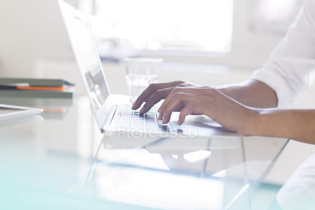 Руки деловой женщины, печатающей на ноутбуке в офисе — стоковое фото