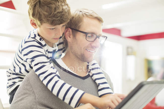 Padre e hijo usando tableta digital - foto de stock