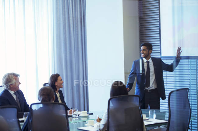 Uomo d'affari che presenta ai colleghi in sala conferenze — Foto stock