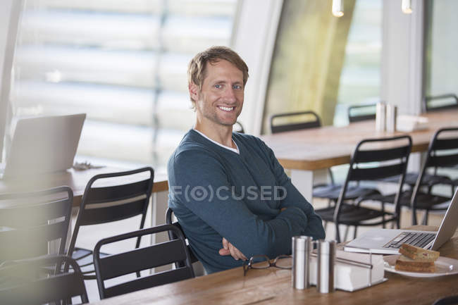 Homme d'affaires utilisant un ordinateur portable à la cafétéria — Photo de stock