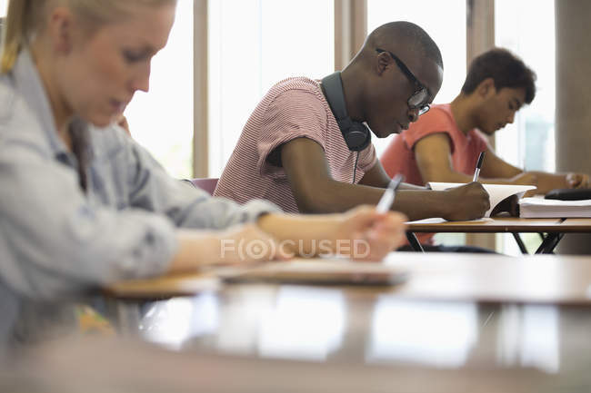 Вид студентов, сидящих за партами во время экзамена в классе — стоковое фото