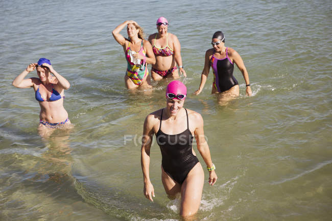 Vista aérea de nadadoras activas femeninas caminando en el océano al aire libre - foto de stock