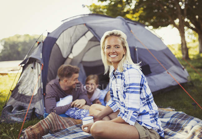 Retrato sorrindo mãe bebendo café com a família na tenda do acampamento — Fotografia de Stock