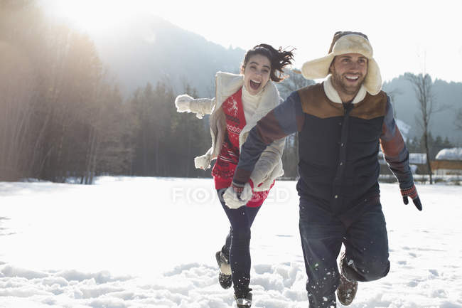 Casal correndo na neve — Fotografia de Stock