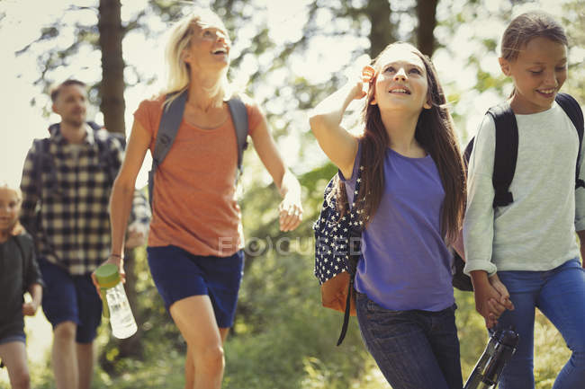 Smiling family hiking in sunny woods — Stock Photo