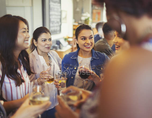 Women friends talking and drinking beer and wine at bar — Stock Photo
