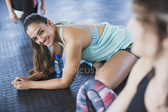 Porträt lächelnde junge Frau dehnt sich im Fitnessstudio — Stockfoto