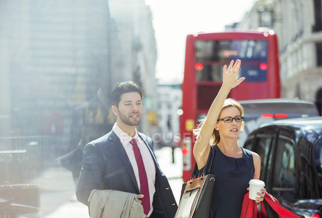 Business people hailing taxi in city — Stock Photo