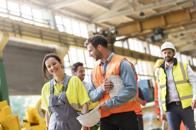 Steel workers walking and talking in factory — Stock Photo