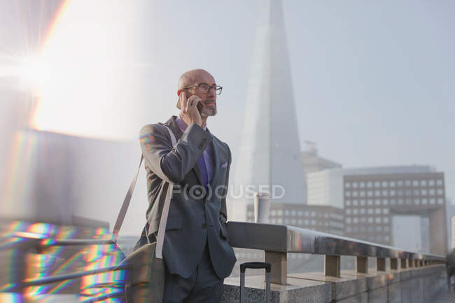 Businessman talking on cell phone on bridge, London, UK — Stock Photo
