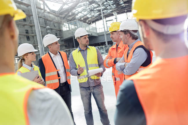 Foreman, engineers and construction workers meeting at construction site — Stock Photo