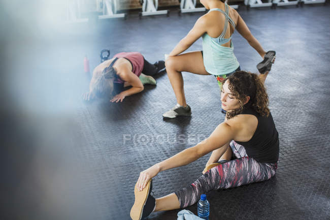 Junge Frauen strecken die Beine in der Turnhalle — Stockfoto