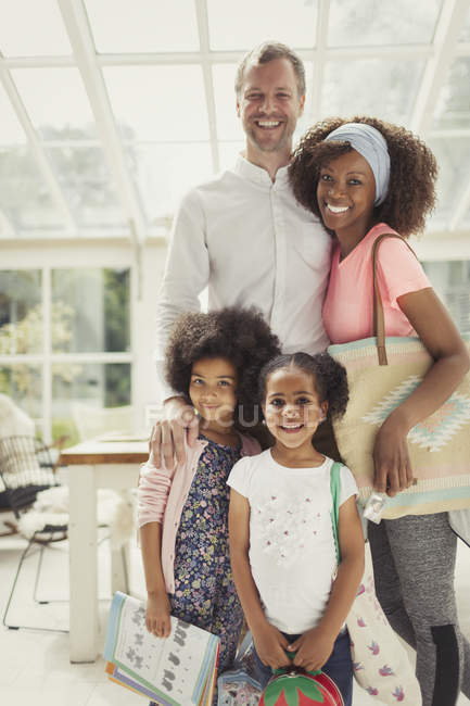 Porträt lächelnde multiethnische junge Familie bereit, das Haus zu verlassen — Stockfoto