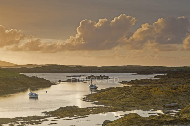 Tranquil sunset view fishing boats on lake, Harris, Outer Hebrides — Stock Photo