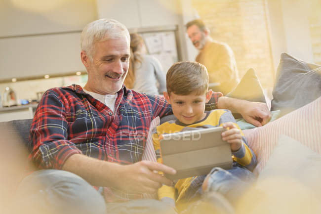 Связывание отца и сына с помощью цифрового планшета на диване — стоковое фото