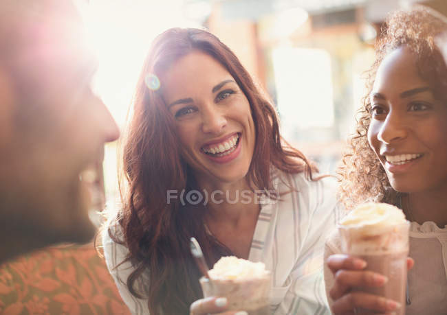 Retrato entusiasta joven bebiendo batido con amigos - foto de stock