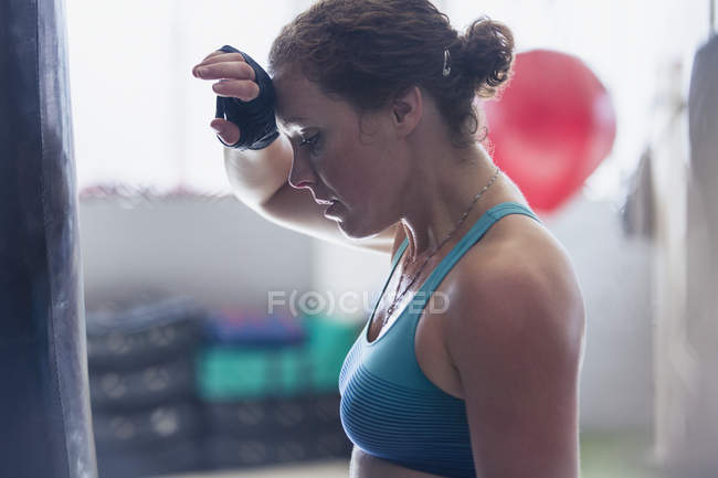 Втомилася жінка-боксер, витираючи піт з брови в спортзалі — стокове фото
