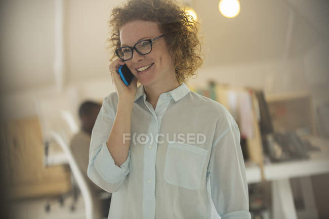 Портрет женщины, разговаривающей по телефону в офисе — стоковое фото